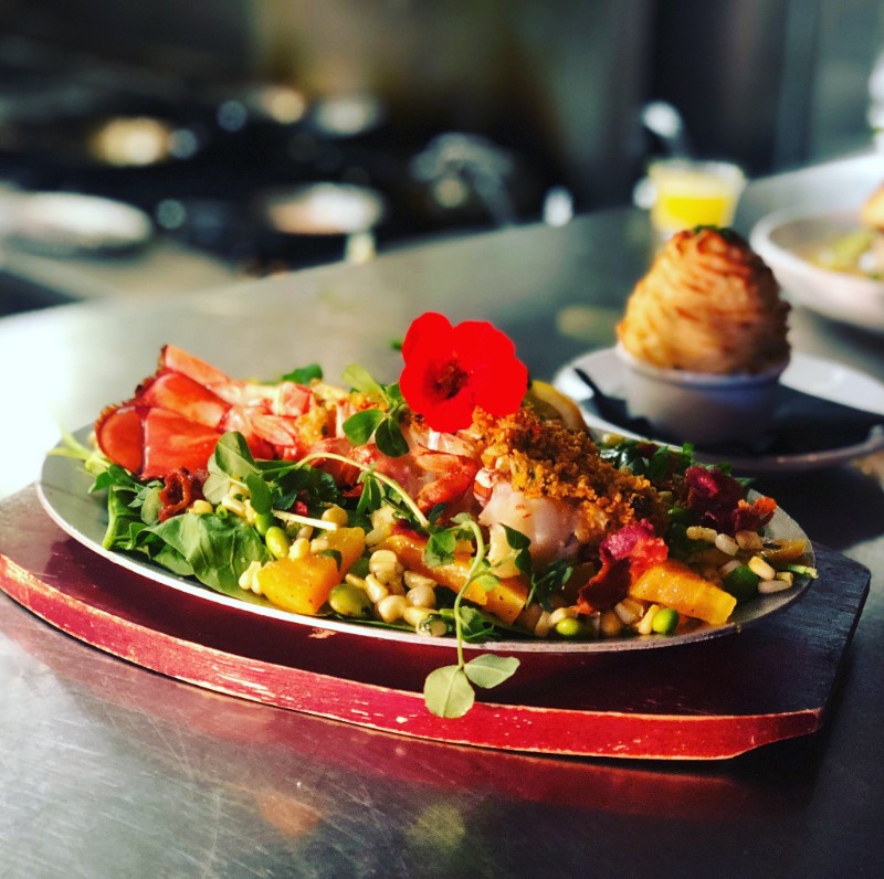 crab and lobster over seasonal vegetables and greens