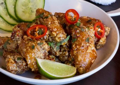 Vietnamese chicken wings with cucumber and lime wedge